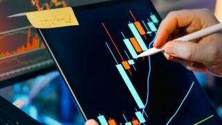 株式市場のチャートを分析するトレーダー