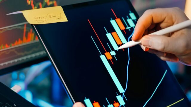 株式市場のチャートを分析するトレーダー