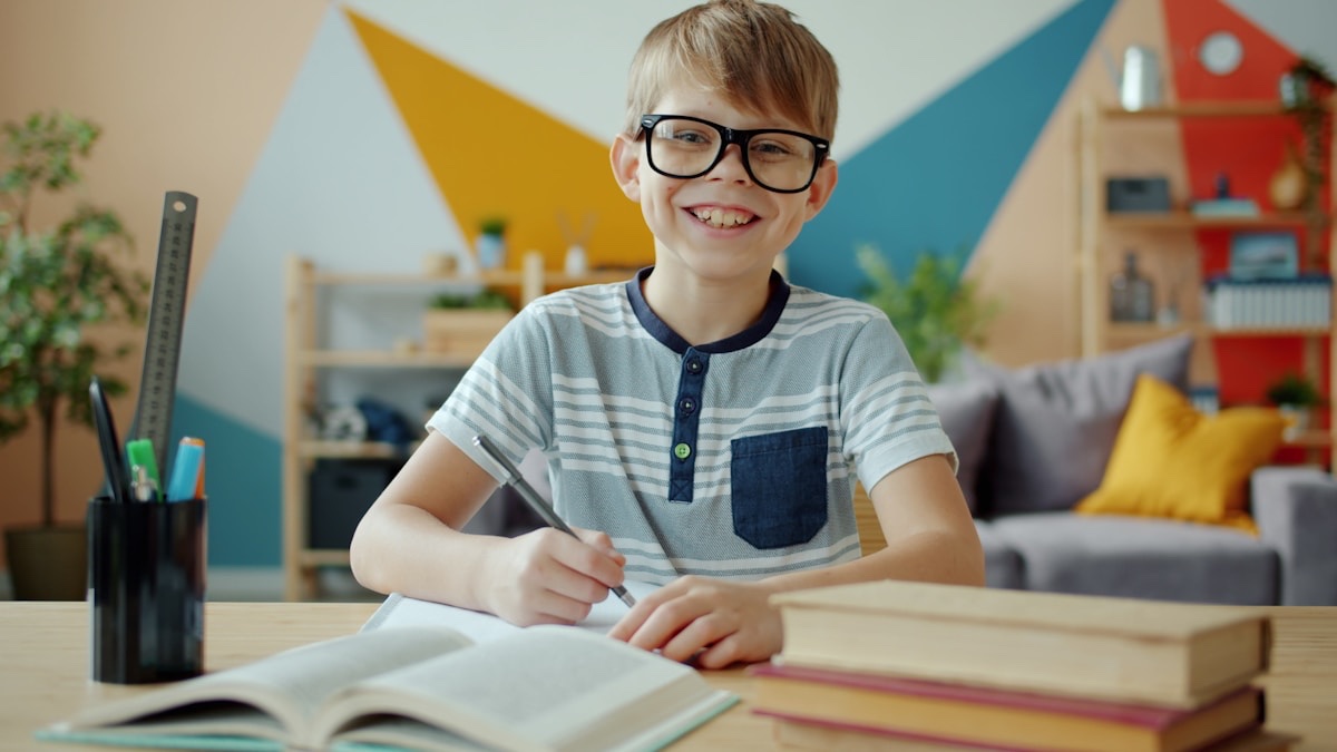机に向かって笑顔で勉強する子ども