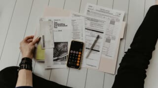 書類と電卓を広げてボーナスの手取りを計算するイメージ